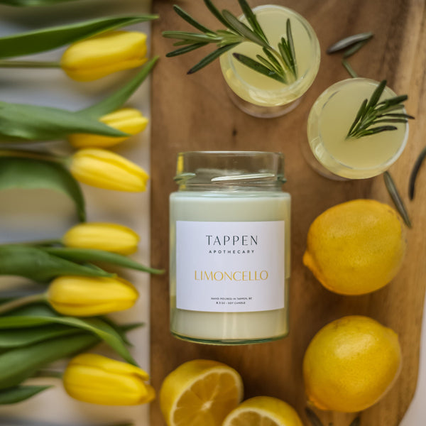 Tappen Apothecary lemoncello candle on a wooden board with lemons and tulips.